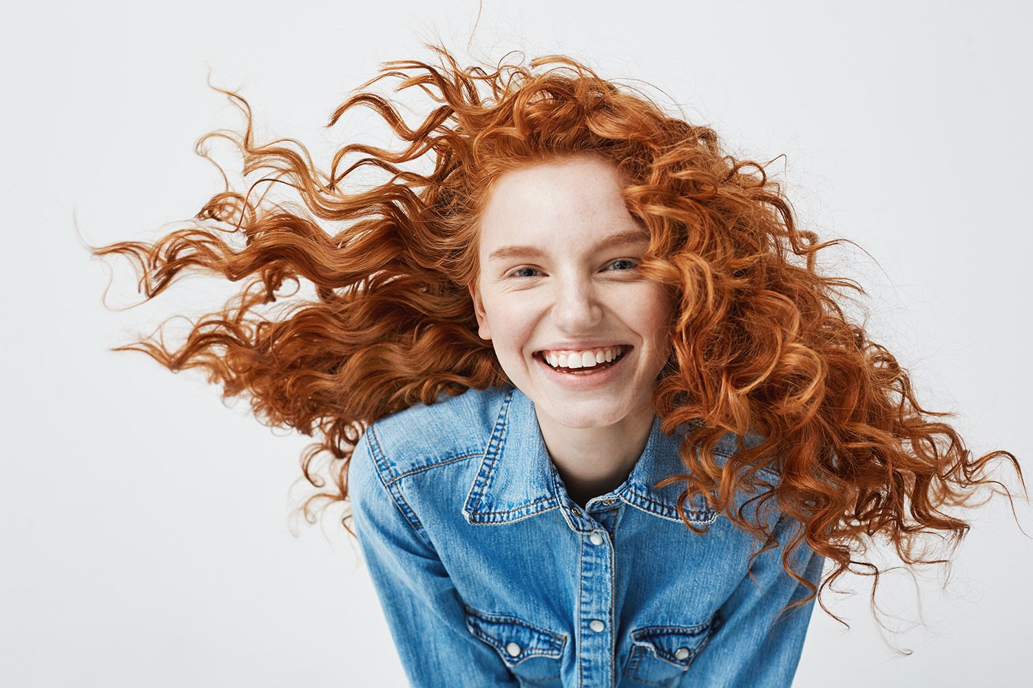 A portrait of a young businesswoman with flowing red hair